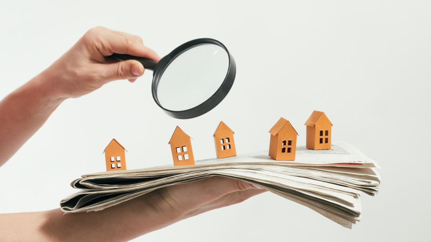 Magnifying glass over wooden houses — “Compare mortgage options and choose the best lender in BC.”